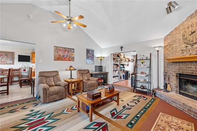 living room featuring ceiling fan, a fireplace, high vaulted ceiling, and light tile patterned floors