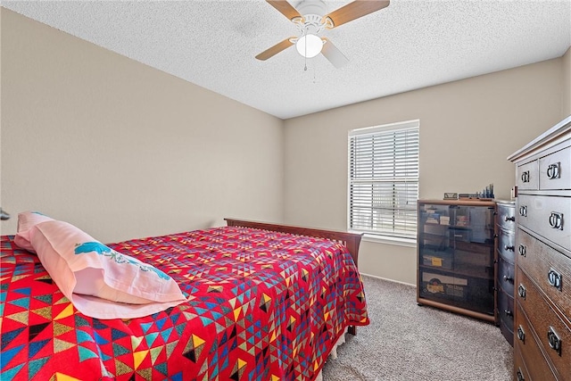 carpeted bedroom with ceiling fan and a textured ceiling