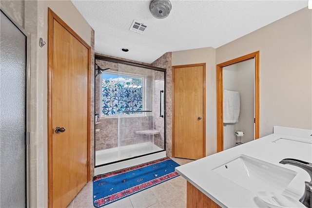 bathroom featuring vanity, a textured ceiling, and an enclosed shower