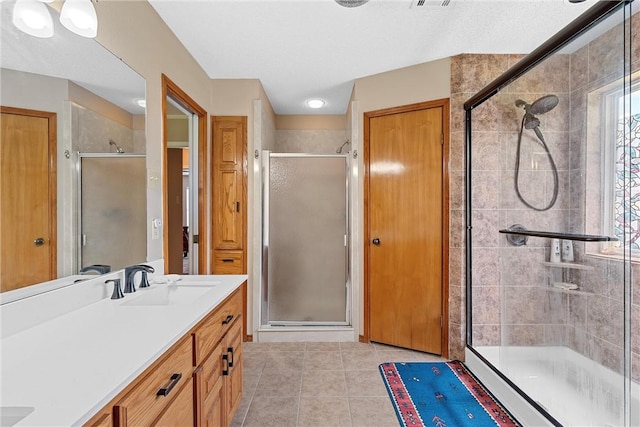 bathroom featuring tile patterned flooring, vanity, and walk in shower