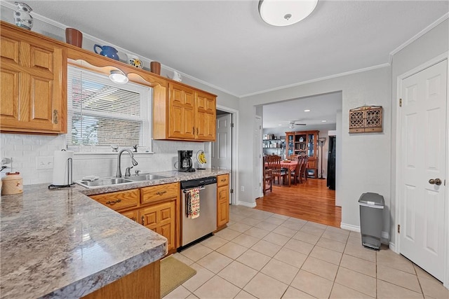 kitchen featuring tasteful backsplash, stainless steel dishwasher, crown molding, sink, and light tile patterned flooring