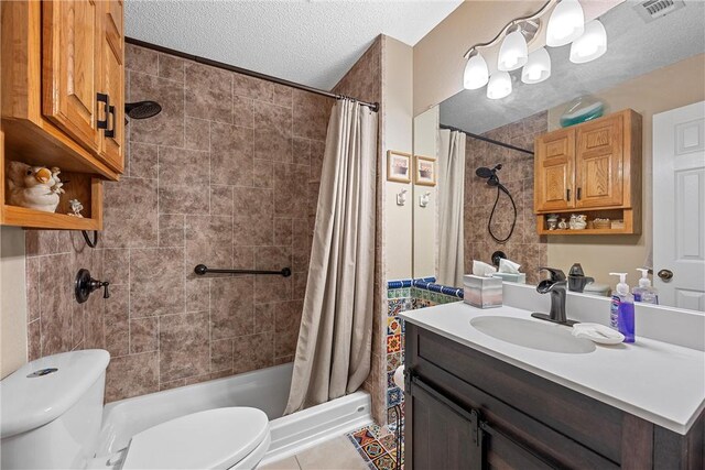 bathroom with vanity, tile patterned floors, a shower with curtain, toilet, and a textured ceiling