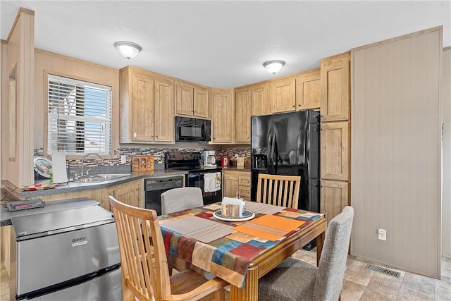 kitchen featuring black appliances, light brown cabinets, sink, and tasteful backsplash