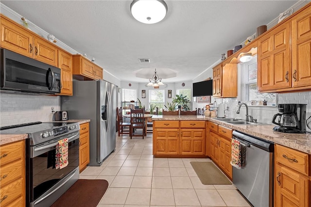 kitchen featuring kitchen peninsula, tasteful backsplash, stainless steel appliances, sink, and light tile patterned floors