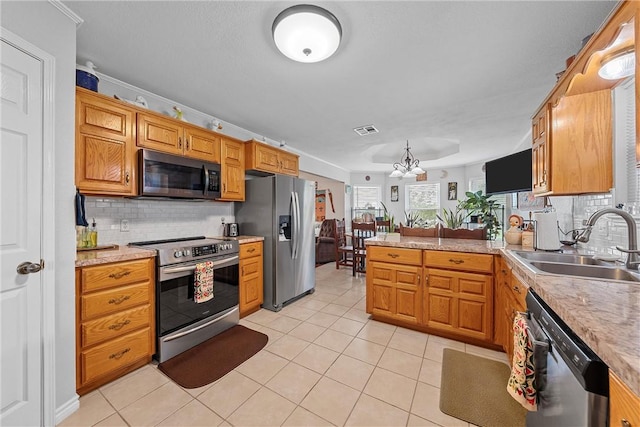 kitchen with sink, decorative backsplash, light tile patterned floors, a notable chandelier, and stainless steel appliances