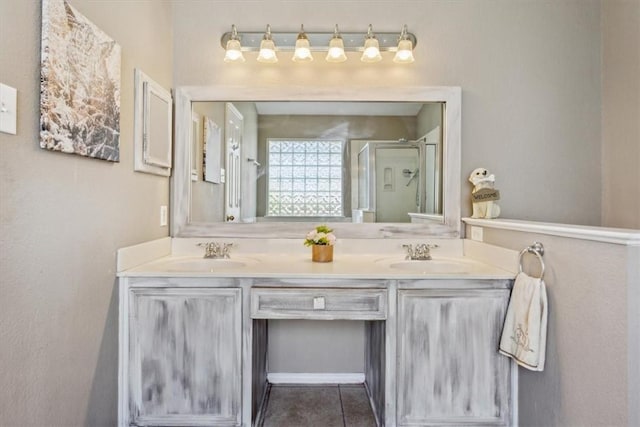 bathroom featuring tile patterned floors, vanity, and a shower with shower door