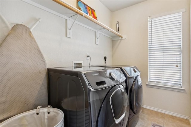 laundry area with washer and dryer, light tile patterned flooring, and a wealth of natural light