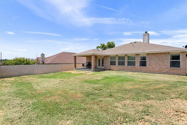 back of house featuring a patio area and a lawn