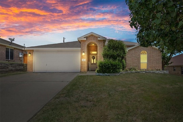 single story home featuring a garage and a lawn