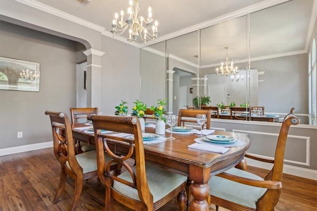 dining room with ornate columns, a chandelier, dark wood-type flooring, and ornamental molding