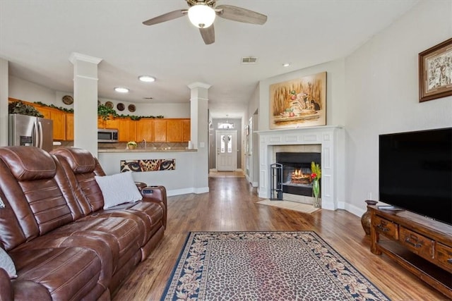 living room featuring a fireplace, ceiling fan, and hardwood / wood-style floors