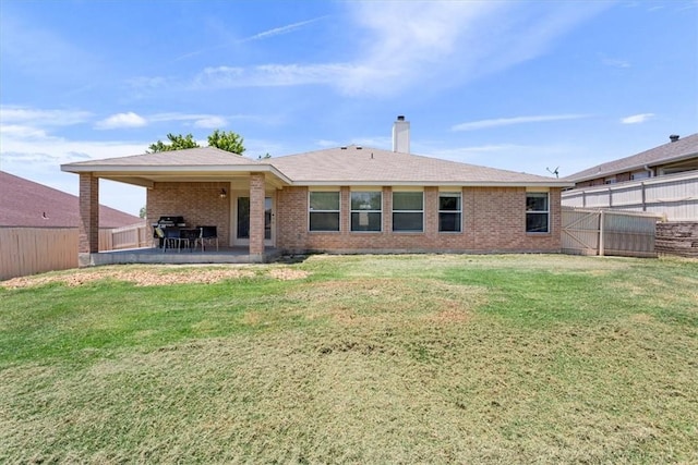 back of house featuring a patio area and a lawn