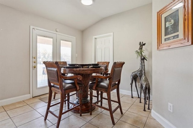 dining space with light tile patterned floors and vaulted ceiling