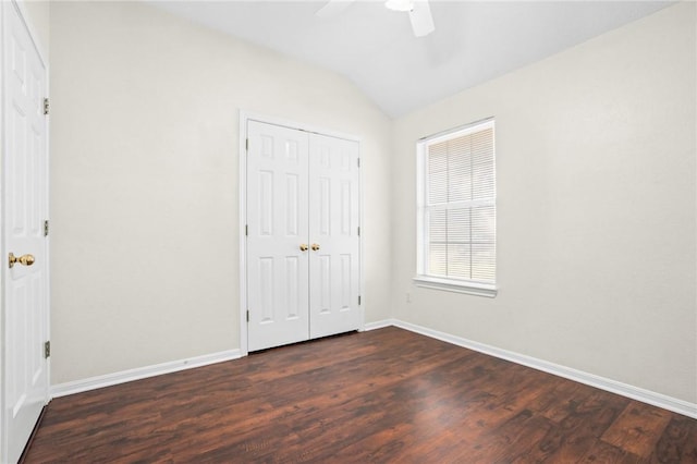 unfurnished bedroom with a closet, dark hardwood / wood-style floors, vaulted ceiling, and ceiling fan