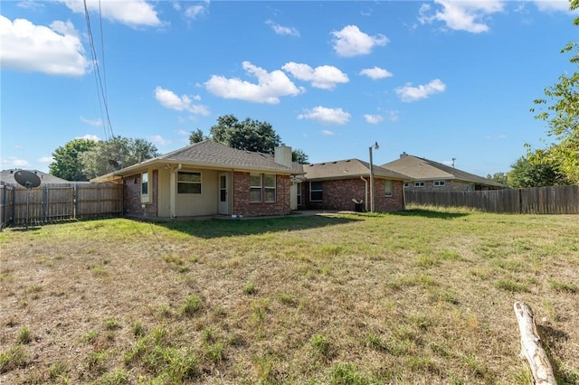 rear view of property featuring a lawn