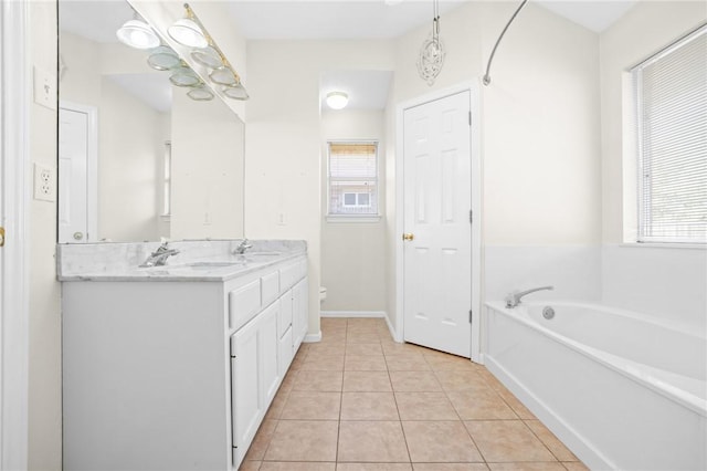 bathroom with tile patterned flooring, plenty of natural light, toilet, and vanity