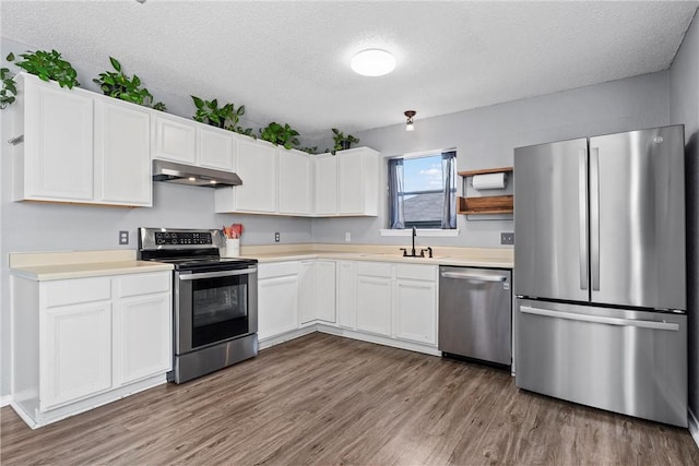 kitchen featuring white cabinets, dark hardwood / wood-style flooring, a textured ceiling, and stainless steel appliances