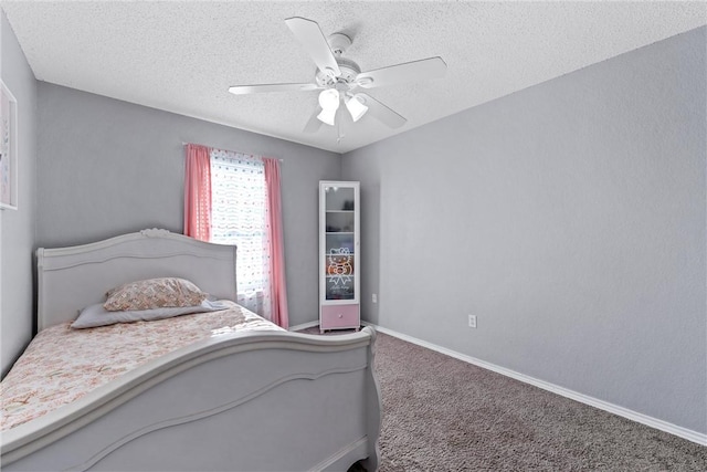 bedroom with ceiling fan, carpet floors, and a textured ceiling