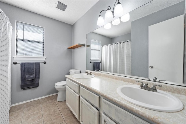 bathroom with toilet, vanity, tile patterned floors, and plenty of natural light