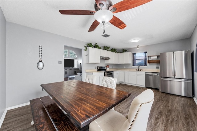 dining area featuring ceiling fan, dark hardwood / wood-style flooring, a textured ceiling, and sink