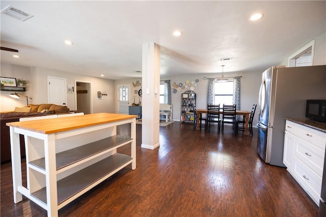 kitchen featuring visible vents, black microwave, dark wood finished floors, butcher block counters, and white cabinets