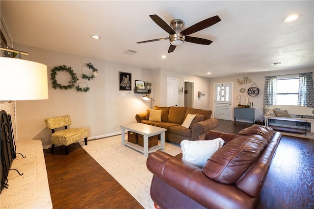 living room featuring a fireplace, recessed lighting, wood finished floors, and visible vents