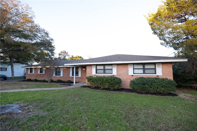 ranch-style house with a front lawn and brick siding