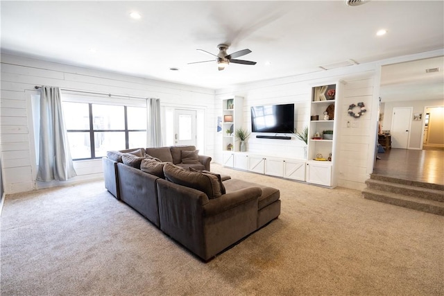 living area featuring recessed lighting, ceiling fan, wood walls, and carpet