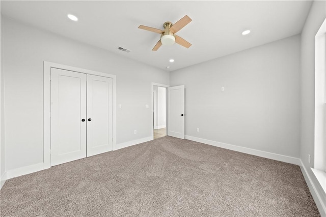 unfurnished bedroom with ceiling fan, a closet, and carpet