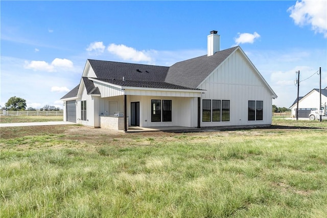 rear view of property featuring a yard and a garage