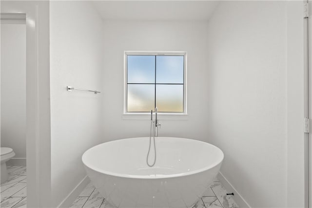 bathroom featuring a washtub and toilet