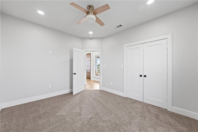 unfurnished bedroom with ceiling fan, a closet, and light colored carpet