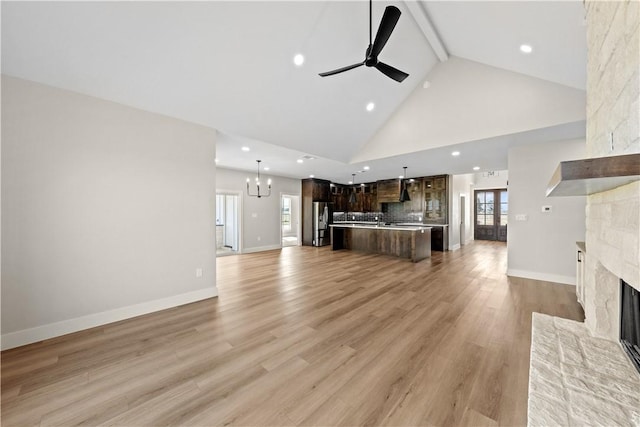 unfurnished living room featuring plenty of natural light, light hardwood / wood-style floors, and a stone fireplace