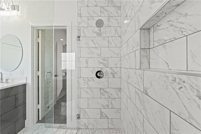 bathroom featuring a shower with door and vanity