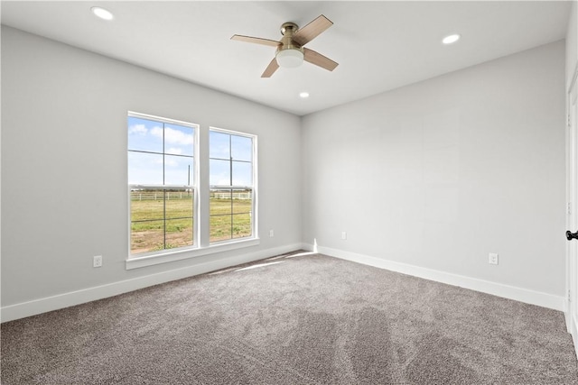 carpeted spare room featuring ceiling fan