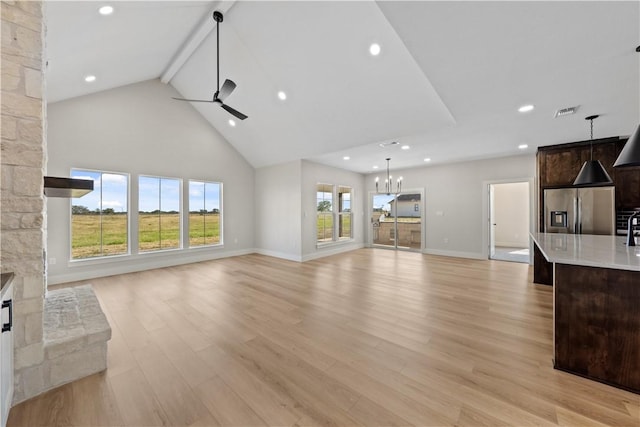 unfurnished living room with light hardwood / wood-style floors, a stone fireplace, and a wealth of natural light