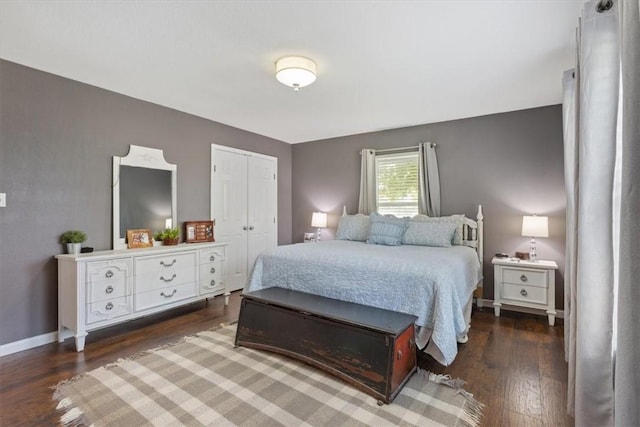 bedroom with dark hardwood / wood-style floors and a closet