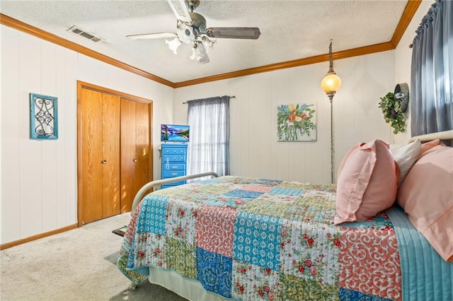 carpeted bedroom with wood walls, ceiling fan, ornamental molding, a textured ceiling, and a closet