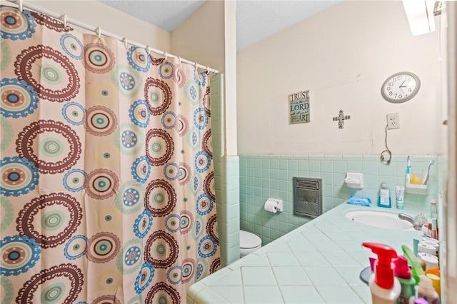 bathroom with a shower with shower curtain, vanity, a textured ceiling, tile walls, and toilet