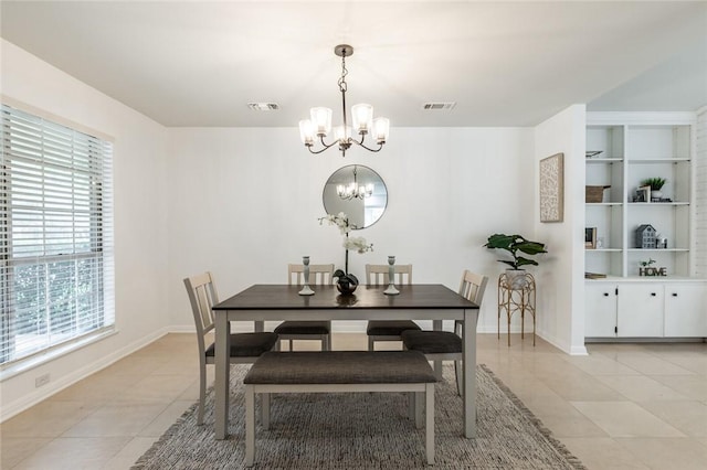 tiled dining area featuring built in features and an inviting chandelier