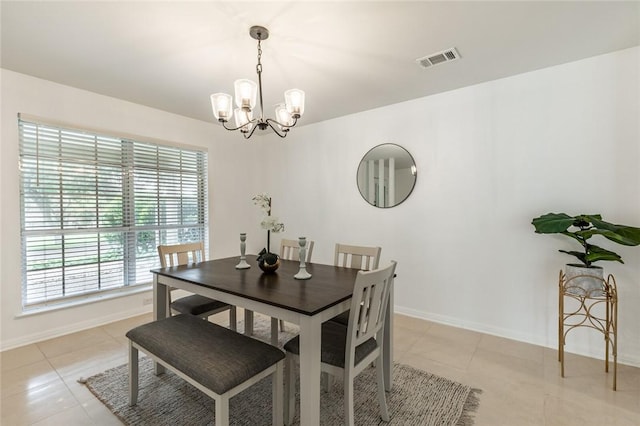 dining area with light tile patterned floors and an inviting chandelier