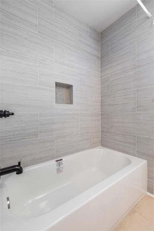 bathroom featuring tile patterned flooring, tile walls, and tub / shower combination