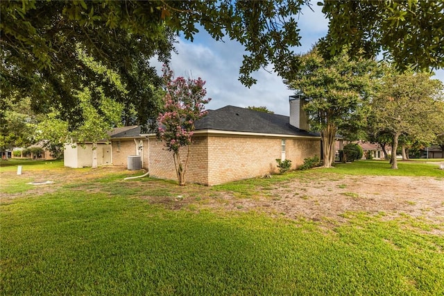 view of property exterior with a lawn and central AC