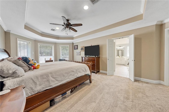 carpeted bedroom featuring ceiling fan, crown molding, connected bathroom, and a tray ceiling