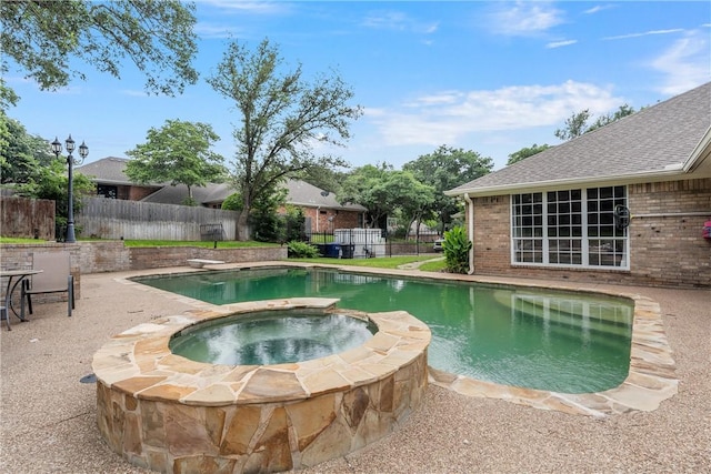 view of swimming pool featuring an in ground hot tub and a diving board