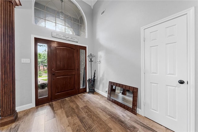 foyer featuring wood-type flooring and a towering ceiling