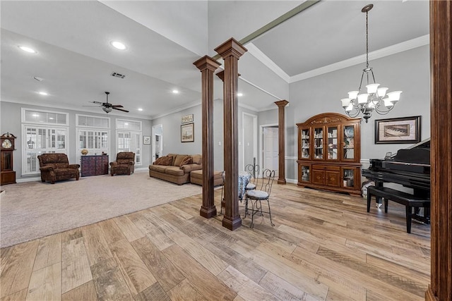 living room featuring ceiling fan with notable chandelier, light hardwood / wood-style flooring, ornate columns, and ornamental molding