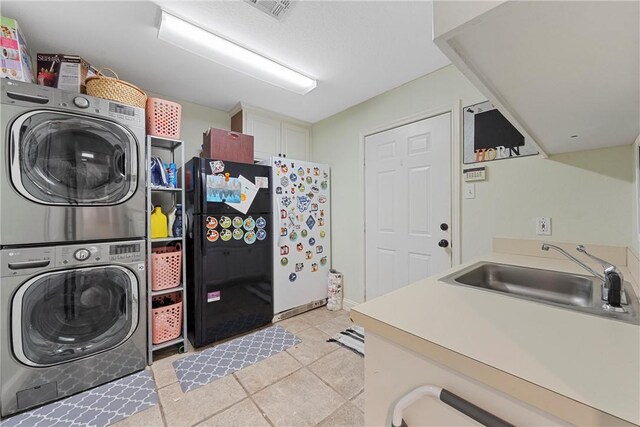 washroom with stacked washer / dryer, sink, and light tile patterned floors