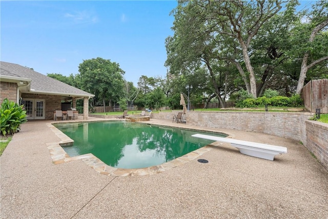 view of pool with a diving board, french doors, and a patio