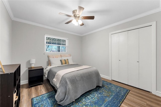 bedroom featuring baseboards, wood finished floors, and ornamental molding